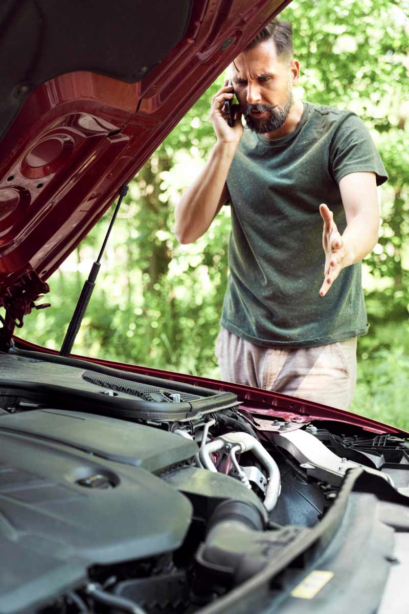 Junger Mann prüft Getriebeschaden bei Schrottauto Ankauf Erftstadt